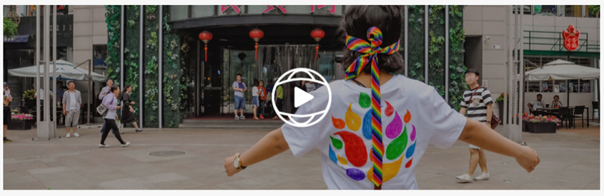 chinese woman blindfolded on street, arms outstretched for a hug from passersby